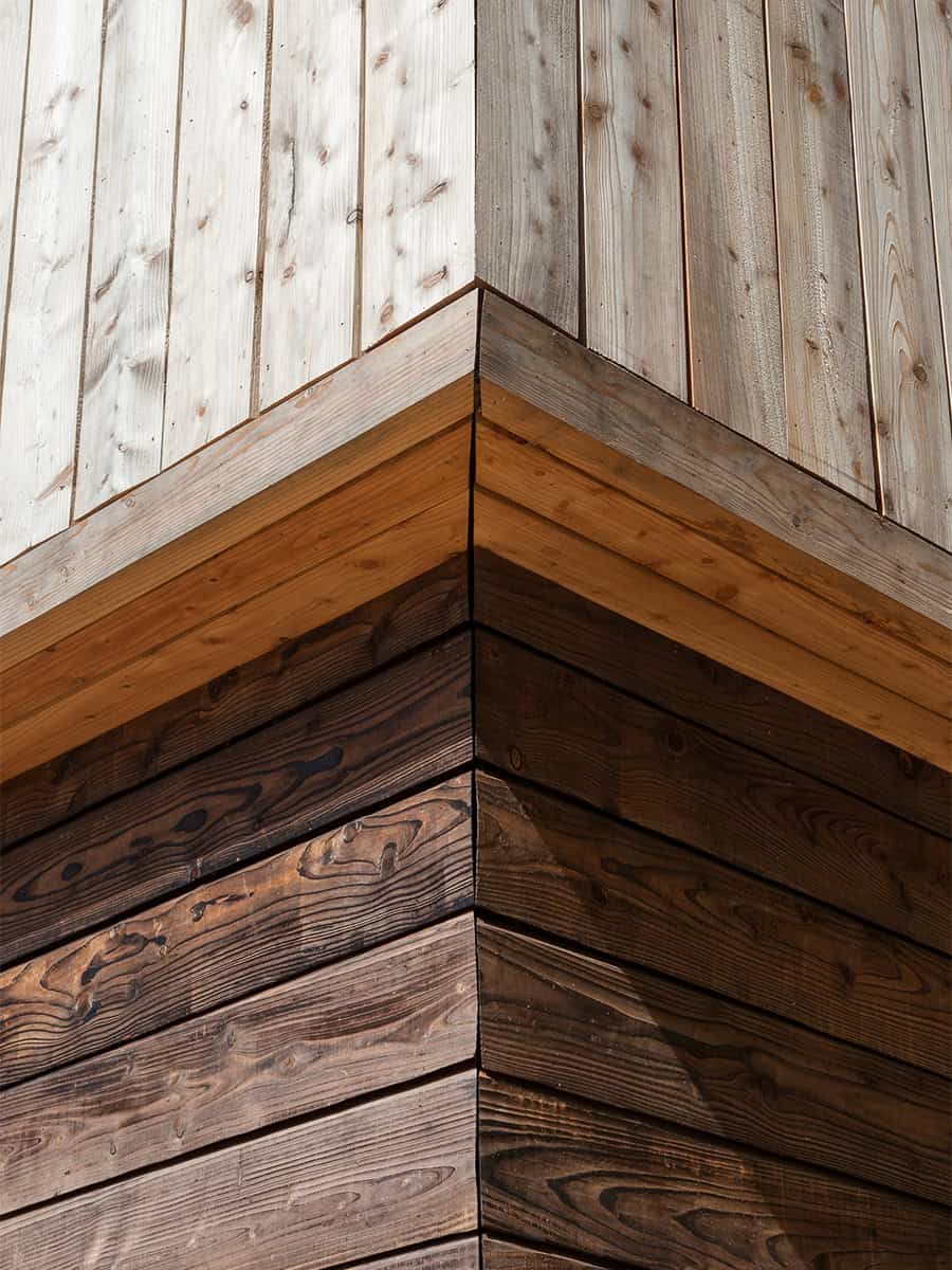 The Larch House close-up of larch timber cladding corner joint detail showing weathered grain
